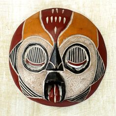 an artistic mask is hanging on the wall