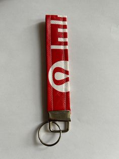 a red keychain with the word life on it is laying on a white surface