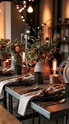 the table is set for dinner with candles and flowers in vases on each side