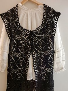 a white blouse with black lace on it