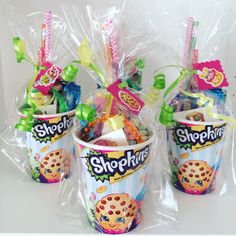 three plastic cups filled with cookies and candies in wrapper on top of each other