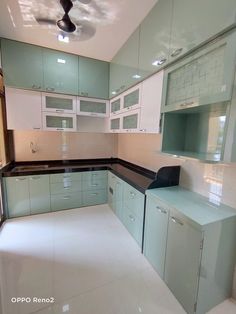 an empty kitchen with white cabinets and black counter tops