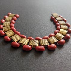 Vintage 1930s Art Deco red early plastic and gold tone repousse panel bracelet. The red plastic sections are in a tank track design and are beautifully smooth and streamlined.  Just a gorgeous sophisticated piece with a length of 7.25 inches, fastening with a simple hook clasp. It is in very good vintage condition. Cocktail Bracelet, Textile Earrings, Big Bracelets, Geometric Bracelet, Statement Collar Necklace, Deco Blue, Machine Age, 1930s Art, Art Deco Lighting