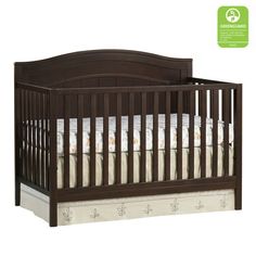 a brown crib with white sheets on it