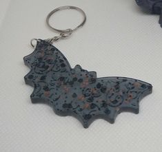 a bat shaped keychain sitting on top of a table