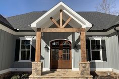 the front entrance to a house with stone steps and pillars on each side, along with an arched wooden door