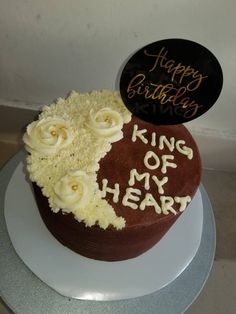 a heart shaped cake with the words happy birthday written on it and white frosting