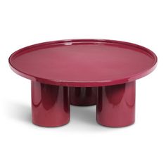 a red table with three legs and a round plate on the top that is shaped like two columns