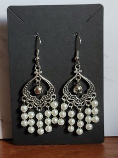 Add elegance to everyday. Whether it be the big day or a Monday, walk with beauty and confidence, and make it your day.. These heart chandelier dangle earrings are made with a filigree heart connector, frosted, crystal and pearl glass earrings with tiny silver bells. Hypoallergenic, stainless steel earring hooks. Lead and nickel free Zinc alloy findings. Soft Silicone Earring backs. *The following items cannot be returned      - Earrings (this is for hygiene reasons) #EastTericiaTradingCo #Uniqu Yule Gifts, Winter Solstice Gifts, Heart Chandelier, Yule Gift, Filigree Heart, Silver Bells, Earrings Beaded, Earrings Unique, Winter Solstice