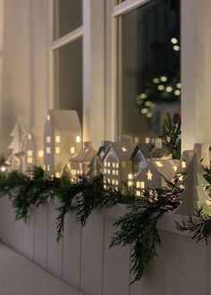 a window sill decorated with christmas lights and greenery