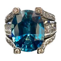 DeKara Designs Collection Modern Inspired Extremely Vibrant Blue Zircon Diamond Engagement Ring. Metal- 18K White Gold, .750. Stones- Genuine Oval Blue Zircon 14 Carats, 36 Round Diamonds G-I Color VS2-SI1 Clarity, 2 Baguette Diamonds G-H Color VS1-VS2 Clarity, 2.05 Total Diamond Carat Weight. Size- 7 1/2. FREE SIZING!!!! An Amazing Modern/Contemporary Diamond Oval Blue Zircon Engagement Ring Handmade in 18K White Gold. The ring features a beautiful and extremely fiery beautiful Blue Zircon that Huge Engagement Rings, Zircon Engagement Ring, Handmade Engagement Rings, Blue Zircon, Vibrant Blue, Baguette Diamond, Oval Diamond, Jewelry Rings Engagement, Diamond Engagement Ring