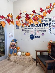 a welcome sign is hanging on the wall next to a wooden bench and two chairs