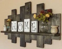 some wooden blocks are sitting on a shelf with vases and flowers in them that spell home