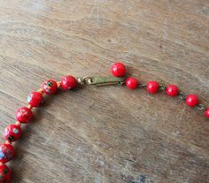 "Vintage glass bead necklace/choker, glass beads are descending in size and are hand knotted between each. Each bead has colorful striped \"balls\" on them that look like little sea urchins. Circa 1940's - 50's (possibly earlier), marked Japan on hook clasp. Largest bead is approx. 3/4\". Necklace is in good condition, please see photos. Offbeat Avenue uses recycled packaging when available." Handmade Red Vintage Choker, Vintage Adjustable Necklaces With Colorful Beads, Adjustable Retro Necklace With Round Beads, Retro Wooden Bead Jewelry, Retro Wooden Round Bead Jewelry, Vintage Beads For Jewelry Making, Adjustable Vintage Beads For Jewelry Making, Retro Adjustable Beaded Necklaces With Round Beads, Vintage Czech Glass Beaded Necklaces With Round Beads