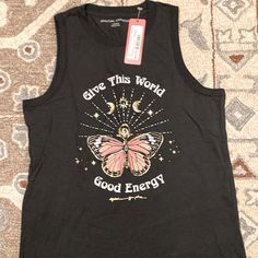 a black tank top that says give this world good energy with a pink butterfly on it