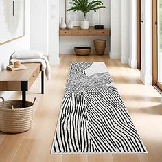 a zebra print runner rug in the middle of a room with white walls and wood flooring