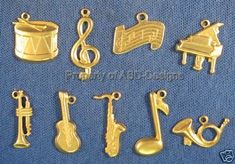 brass plated musical instruments charms on blue fabric with clippings to the side