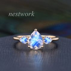 a blue ring with three pear shaped stones on it and the words network above it