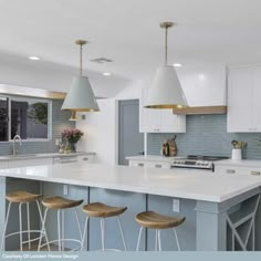 a large kitchen with white cabinets and counter tops