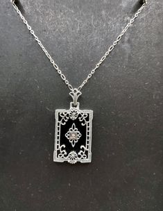 "The piece is absolutely beautiful. A detailed filigree style black onyx pendant. The center is adorned with a pave set diamond accent and the contrast between the colors of black and silver really make this piece pop! You will love this in real life! The necklace is 18\" long and comes with an easy-to-use strong trigger clasp (lobster claw). This is a great example of a period piece and would be a great addition to your Art Deco / Victorian collection.  I do have some other pieces available as well and matching bracelets and earrings so be sure to check out some of my other listings too.! Thanks for looking and if you have any questions, always feel free to ask :)." Black Onyx Pendant, Victorian Necklace, Goth Necklace, Filigree Pendant, Necklace Vintage, Matching Bracelets, Style Necklace, Art Deco Style, Deco Style