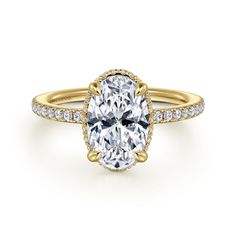 an oval cut engagement ring with pave set diamonds on the band and center stone in yellow gold