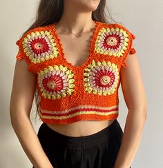 a woman wearing an orange crocheted crop top