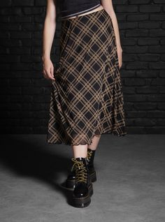 Mix up your plaid skirt rotation with this midi style. It has a mesh overlay printed with black and brown plaid. It's fully lined with an elastic waistband.95% polyester; 5% spandexWash cold; dry lowLength: 29''ImportedListed in junior sizes