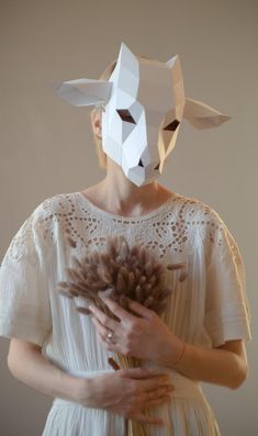 a woman wearing a paper mask holding flowers