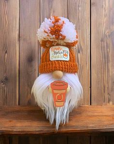 an orange and white knitted santa claus hat on top of a wooden bench