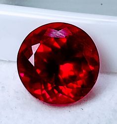 a bright red diamond sitting on top of a white counter next to a window sill