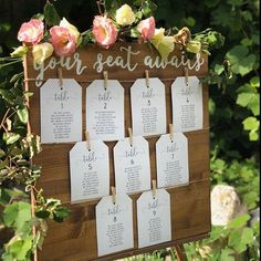 a wooden sign with seating cards attached to it