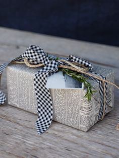 a gift wrapped in burlap with a gingham ribbon tied around it