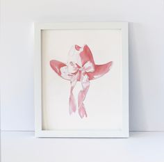 a pink and white cowgirl's hat is mounted in a white frame on the wall