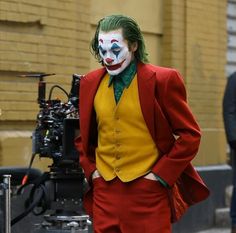 a man dressed as the joker standing in front of a camera