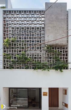 an apartment building with plants growing on the roof