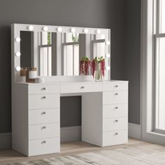 a white vanity with lights on it in front of a large window and rugs