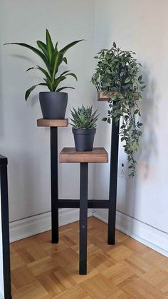 two plant stands with plants on them in a room