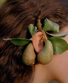 a close up of a person with fruit in their ear