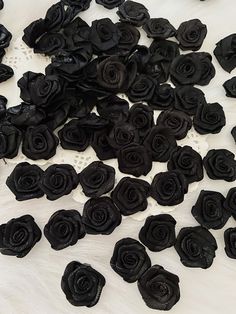 there are many black flowers on the white tablecloth and one is cut in half