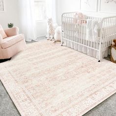 a baby's room with a crib, rocking chair and rug on the floor