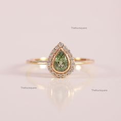 a ring with a pear shaped green and white diamond in the center, surrounded by small diamonds