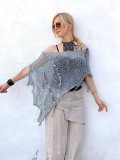 This boho cotton blend hand-knitted fringed poncho in grey and aqua blue tones is light and airy. It is a four-season piece and is ideal for layering  The color palette is definitely jeans friendly.  STYLE This dressy/casual piece is an excellent travel companion.  Works well with jeans, leggings, swimsuit or over a solid dress adding a flowy elegance of a shawl. Endless in its versatility and fits most sizes make it a great gift idea. Material: Cotton Blend WAYS TO WEAR SEE FAQ's FOR WAYS TO WE Bohemian Knitted Shawl For Beach, Bohemian Knit Poncho For Spring, Bohemian One Size Knit Shawl, Bohemian One-size Knit Shawl, Bohemian Knitted Poncho For Spring, Bohemian Knit Shawl One Size, Bohemian Hand Knitted Poncho For Festivals, Bohemian Knit Poncho With Fringe, Bohemian Knit Poncho