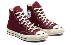 a pair of maroon converse sneakers with white laces on the top and bottom side