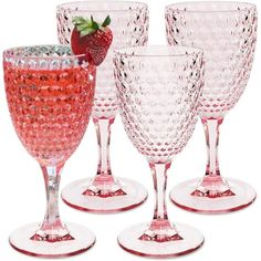 four wine glasses with strawberries on the rims