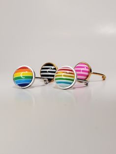 Add a quick pop of PIZZAZZ to your look with these super comfortable stainless steel and resin rings. Squeeze or pull appart the arms to adjust to your perfect fit. Made with stainless steel, the colour is true and not just a plating that will flake off over time. No green fingers here! Trendy Multicolor Metal Rings, Adjustable Multicolor Nickel-free Jewelry, Trendy Enamel Round Rings, Adjustable Modern Stainless Steel Ring, Nickel-free Multicolor Novelty Jewelry, Adjustable Jewelry For Pride Festival Gift, Modern Rainbow Round Jewelry, Modern Round Rainbow Jewelry, Modern Adjustable Multicolor Jewelry