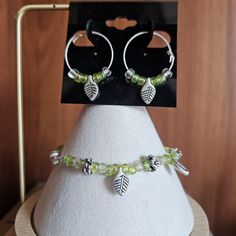 #B&E4 Bracelet size 7, magnetic clasp. Clear & iridescent green beads, with metal leaves & flowers. Hoop style earrings. Iridescent Green, Spring Hill, Green Beads, Metal Leaves, Leaf Flowers, Style Earrings, Magnetic Clasp, Green Bead, Bracelet Sizes