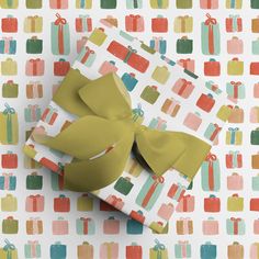 two wrapped presents are sitting on top of a colorful wrapping paper with bows and ribbons