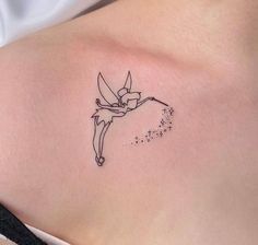 a small tattoo on the back of a woman's stomach, depicting a fairy tinkerbell