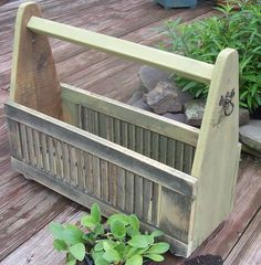 a planter with plants growing in it on a wooden deck next to some rocks