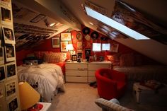 an attic bedroom with two twin beds and pictures on the walls, along with a red chair